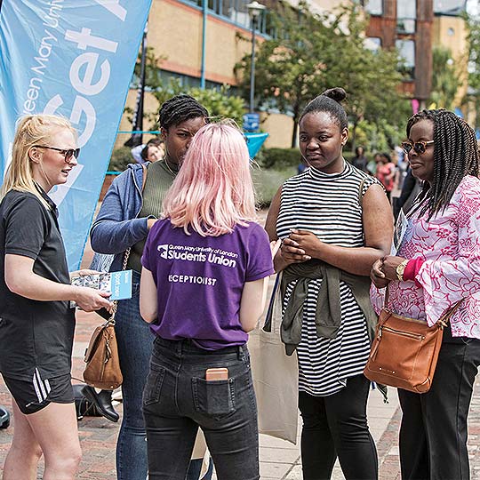 A QMSU receptionist talking to four students